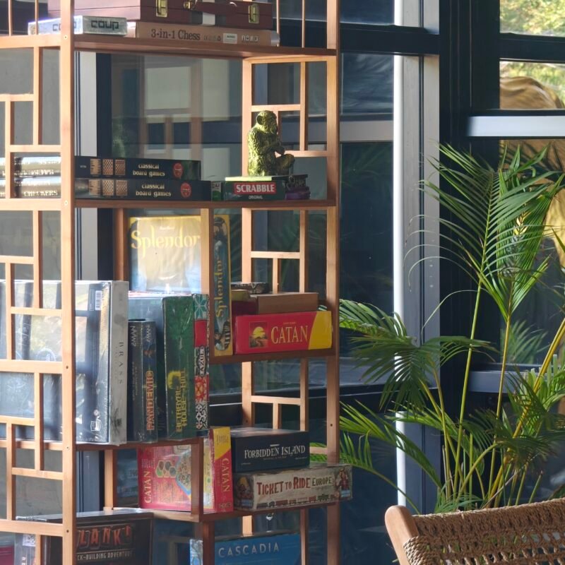 Wooden shelf filled with board games and a decorative monkey statue